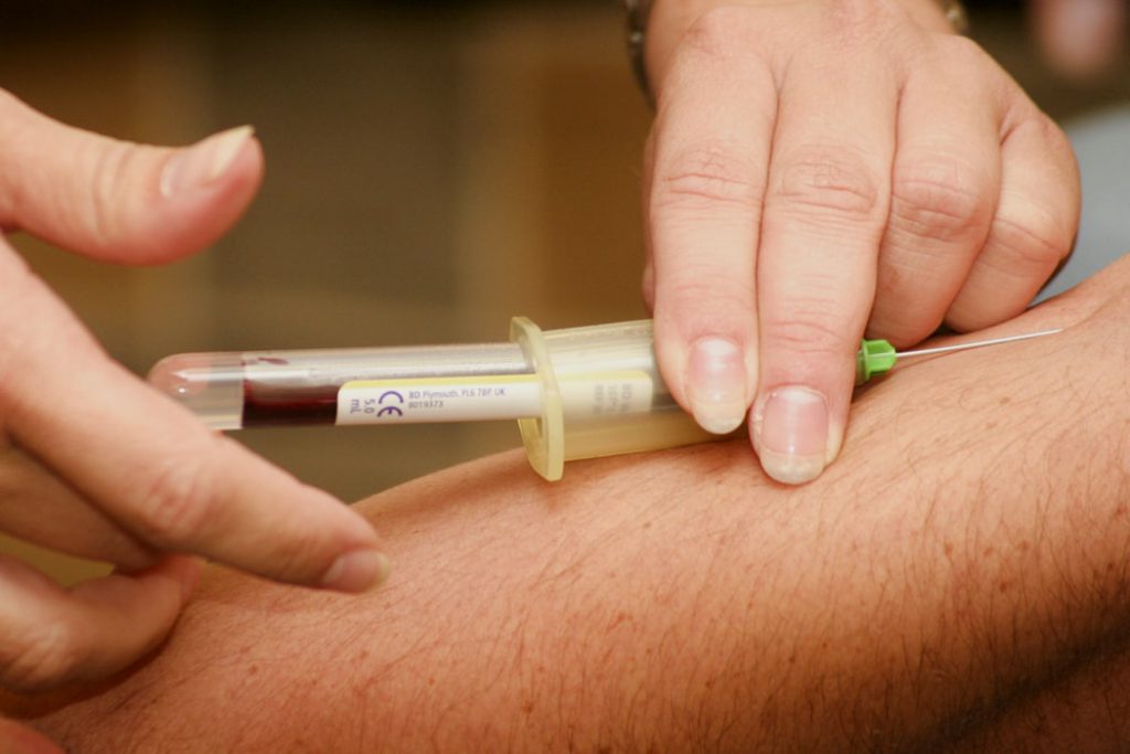 Persona sacando sangre de brazo
